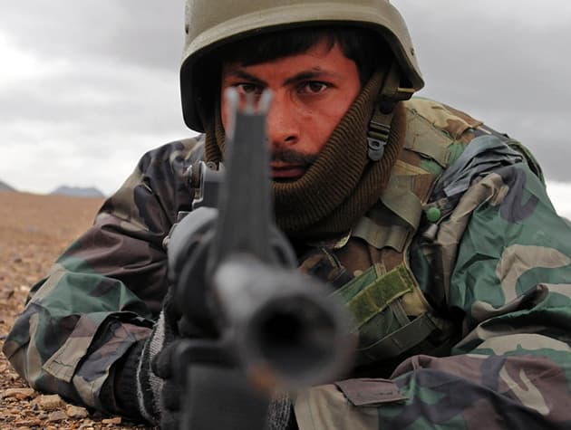 Afgán katonai egyenruhát viselő férfi végzett amerikai katonákkal